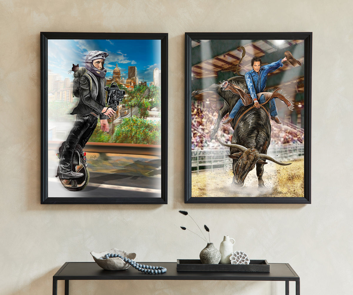 Two framed vertical art prints displayed side-by-side on a beige wall above a black console table. The left print shows a man in a black leather jacket riding a unicycle, set against a city skyline. The other riding a Longhorn bull. 1 Wheel Woody and Longhorn Bull Rider by Doug LaRue