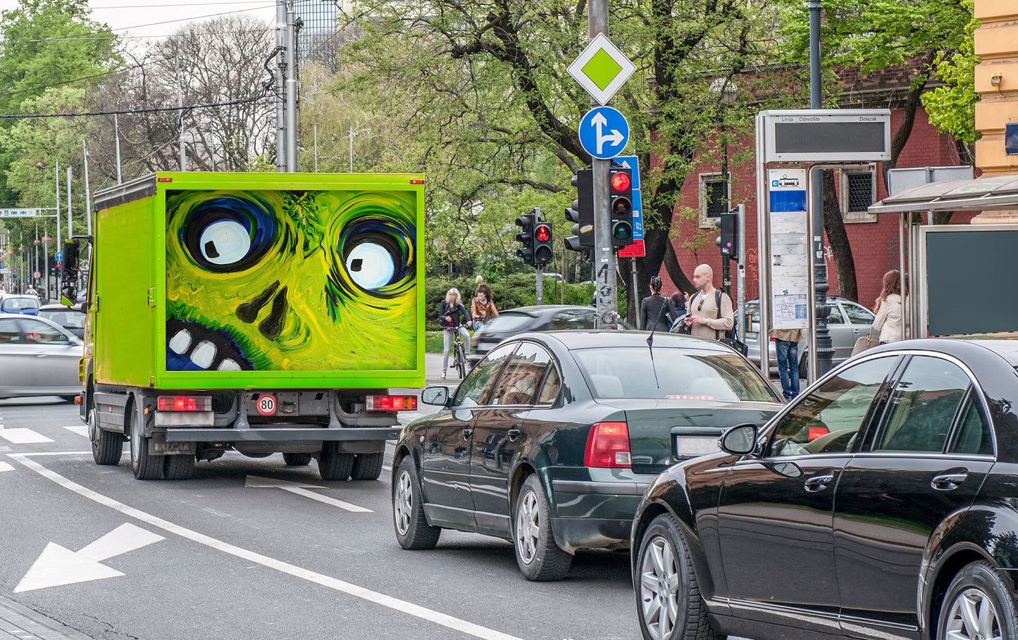 Green truck with Crazy Eyes oil painting on the cargo door in heavy traffic on a city street