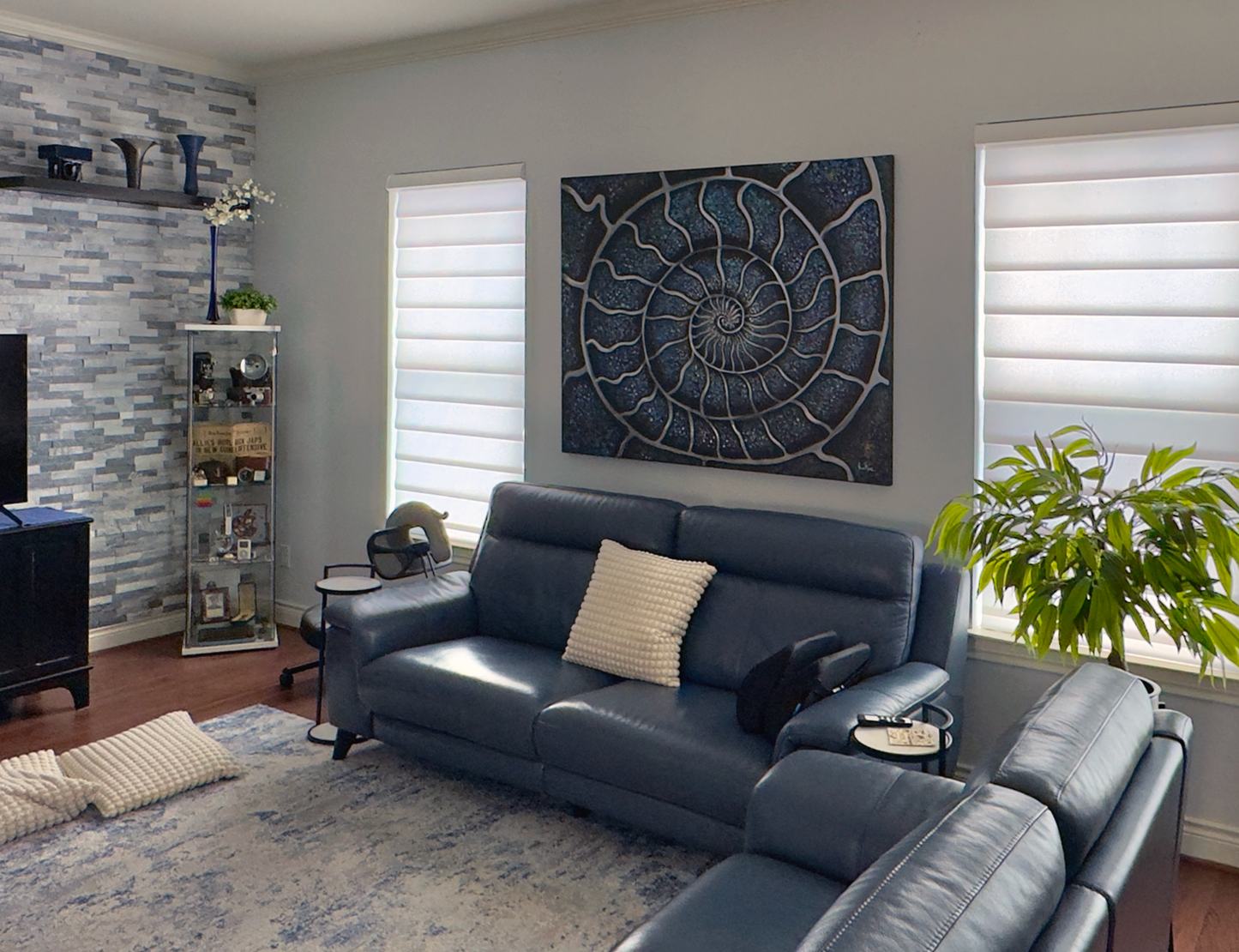 Ammonite abstract painting by Doug LaRue on a living room wall over a turquoise couch.
