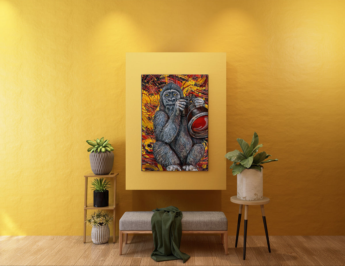 A framed wall art print showing a stylized gorilla painting in warm orange, red, yellow, and blue tones, displayed on a mustard yellow wall above a bench with plants and side tables in a staged interior. Gorilla Cam bob Doug LaRue