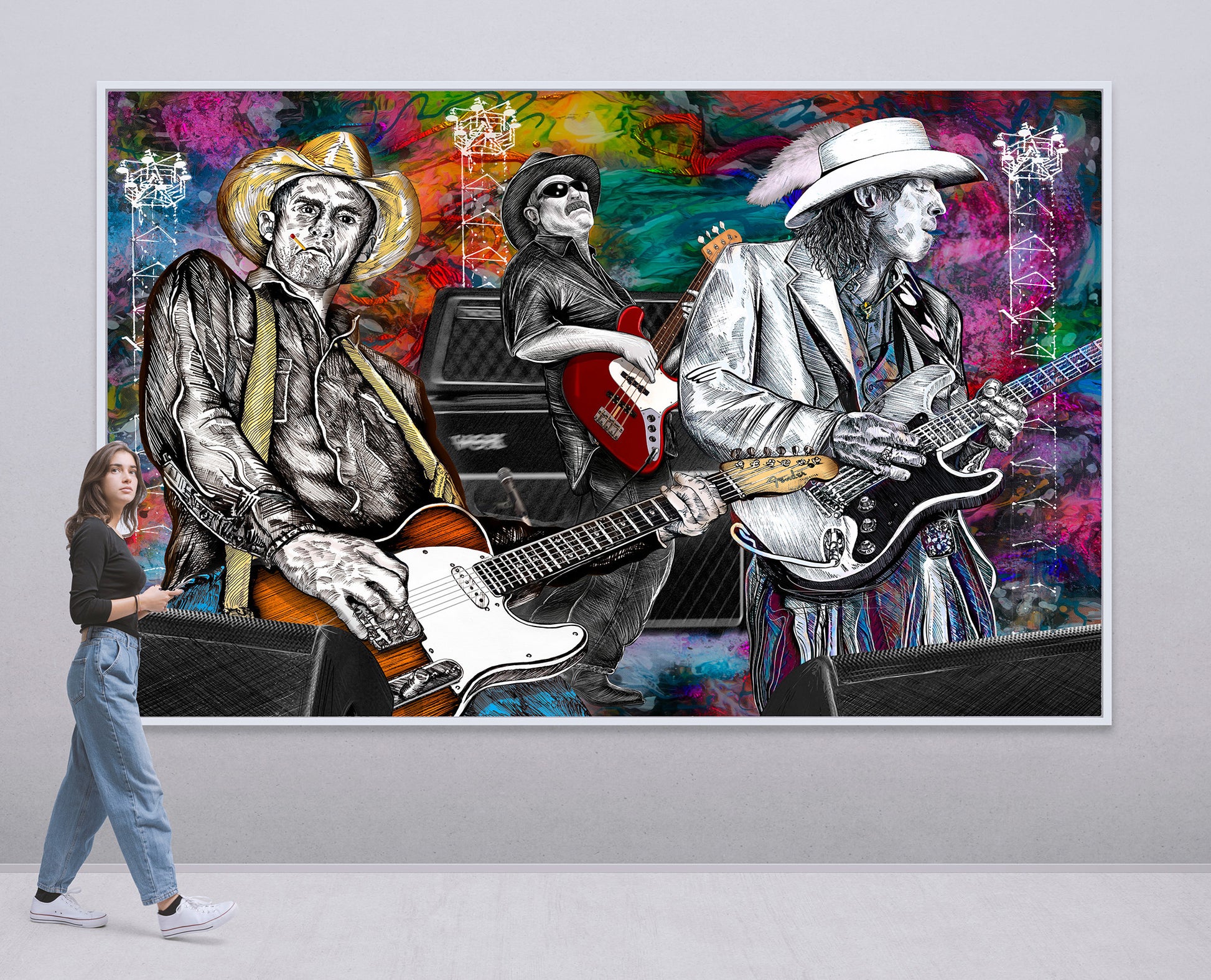 A large framed wall art print depicting three illustrated guitarists in black-and-white suits against a vivid multicolor painted background, shown hanging on a light gray wall with a woman walking past it for scale. Slim, Red and Stevie Ray by Doug LaRue