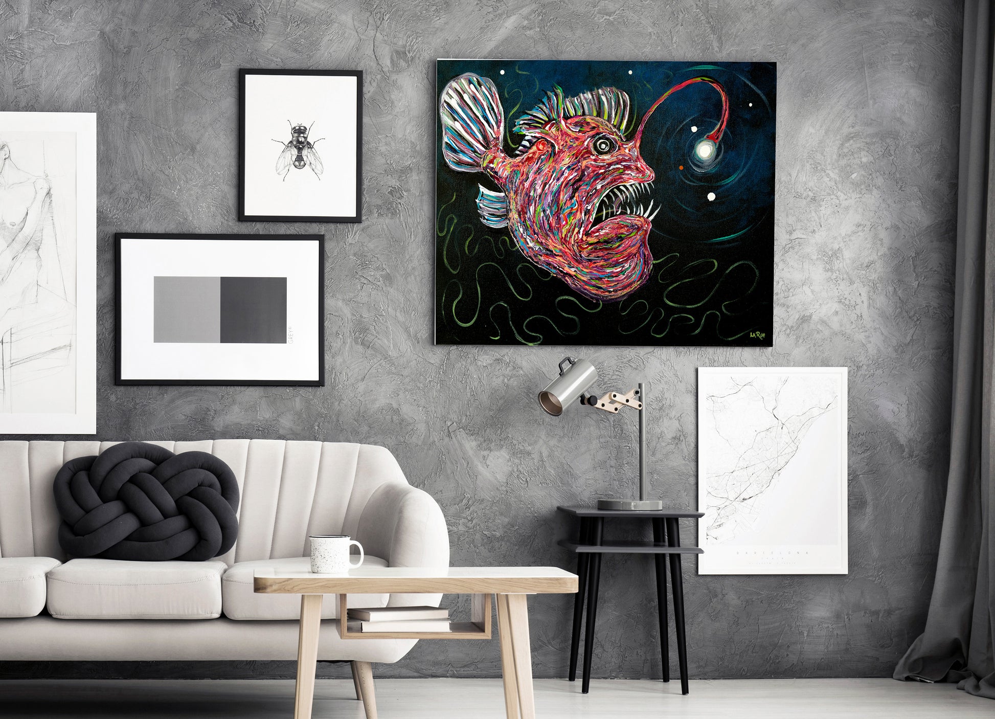 A colorful abstract fish wall art print hangs on a textured gray wall in a modern living room setting with a sofa, side table, and other framed art.