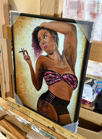 Framed artwork of a woman in a bikini with tattoos, held on an easel. Derae's Accoutrements by Doug LaRue