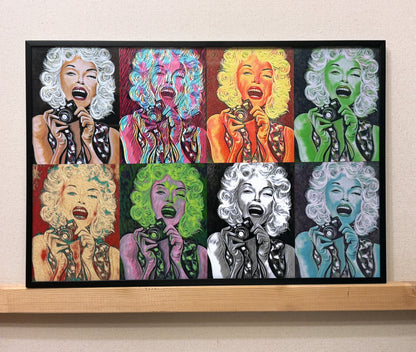A framed pop art print featuring eight stylized portraits of Marilyn Monroe in different colorways, mounted on a light beige wall above a wooden shelf.