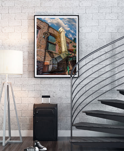 Pikes Alley photograph, Seattle by Doug LaRue in a black metal frame with a white mat next to a spiral staircase on a white brick wall