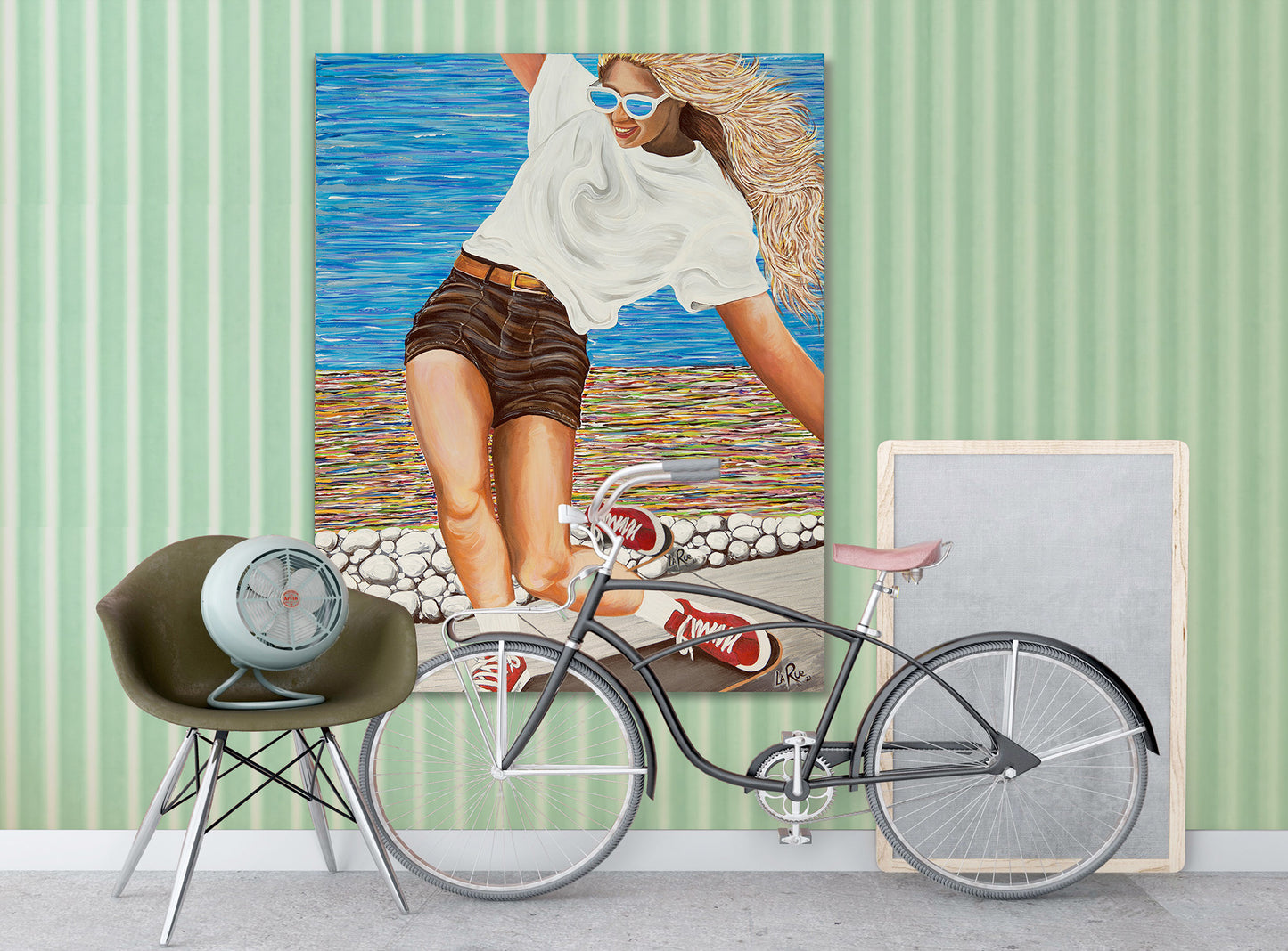 SK8 Girls Like You acrylic painting by Doug LaRue • Woman skateboarding on a wooden deck with a colorful abstract oceanside beach path.Bicycle in front of a painting of a woman on a beach with a green striped wall.