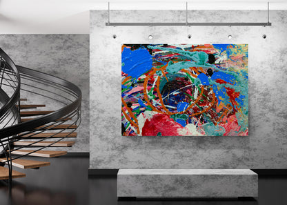 A colorful abstract canvas painting with vibrant blue, red, orange, green, and black brushstrokes, displayed on a textured gray wall in a modern interior setting with a spiral staircase on the left. Sweetbriar Deep Ellem b y Doug LaRue